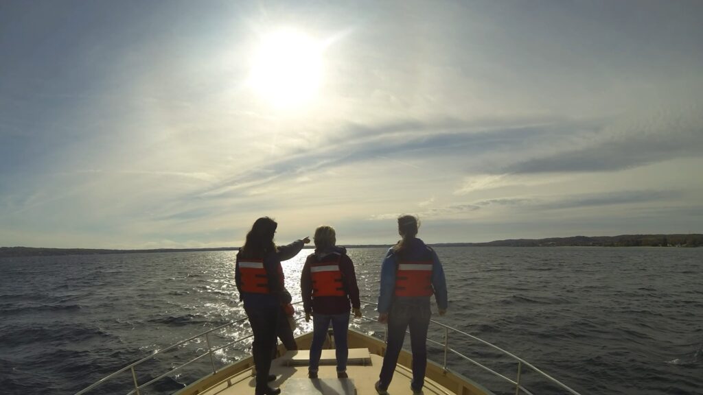 College students riding a boat for water studies course in Traverse City, Michigan